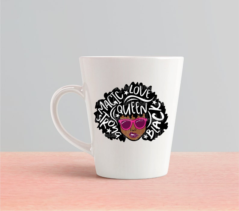 May include: White ceramic mug with a black and white graphic of a woman with an afro hairstyle. The graphic includes the words "Magic", "Strong", "Queen", "Love", and "Black". The woman is wearing pink sunglasses.