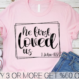 May include: Pink t-shirt with black text that reads "He first loved us 1 John 4:19".