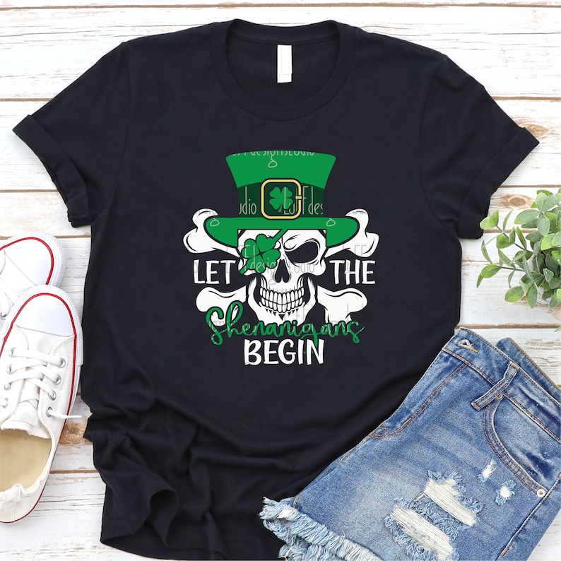 May include: Black t-shirt featuring a white skull wearing a green leprechaun hat and the text "Let the Shenanigans Begin".