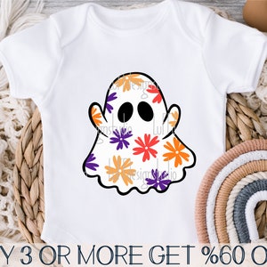 May include: A white baby onesie with a black outline of a ghost with a floral pattern inside. The ghost has two black eyes and a black mouth. The floral pattern is in shades of orange, yellow, purple, and red.
