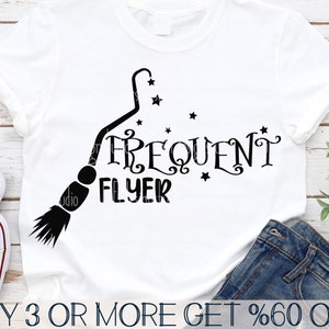 以下が含まれることがあります： 星が描かれたほうきと「Frequent Flyer」という文字が書かれた白いTシャツ。画像の下部には「BUY 3 OR MORE GET %60 OFF」という文字が書かれている。