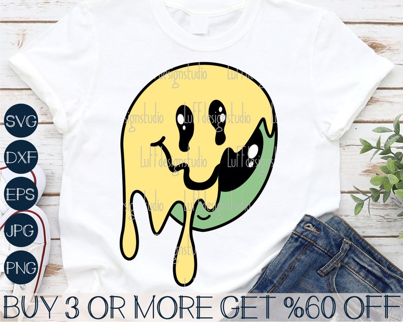 May include: A yellow and green smiley face graphic with dripping edges. The graphic is on a white t-shirt. The text "BUY 3 OR MORE GET %60 OFF" is at the bottom of the image.