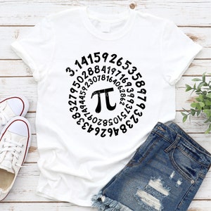 May include: White t-shirt with a black circle design featuring the mathematical constant pi and the digits of pi in a spiral pattern.
