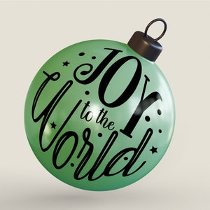 May include: A green Christmas bauble with the text "Joy to the World" in black script lettering. The bauble has a black string for hanging.