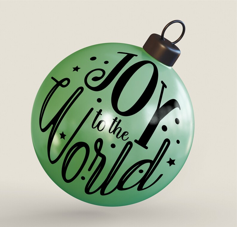 May include: A green Christmas bauble with the text "Joy to the World" in black script lettering. The bauble has a black string for hanging.