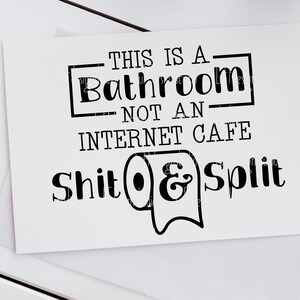 May include: Black and white sign with the text "This is a bathroom, not an internet cafe. Shit & Split" with a toilet paper roll icon.