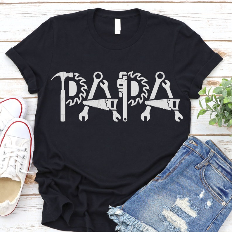 Peut inclure: T-shirt noir avec un motif blanc d'outils orthographiant le mot "PAPA".