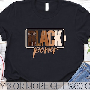 May include: Black t-shirt with the text "Black Power" in a battery-shaped graphic with brown, tan, and black colors.
