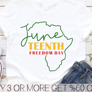 Puede incluir: Camiseta blanca con un contorno verde del continente africano y el texto "Juneteenth Freedom Day" en letras verdes, amarillas y rojas.