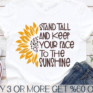 May include: A white t-shirt with a brown sunflower graphic and the text "Stand Tall and Keep Your Face to the Sunshine".