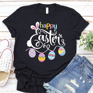 May include: Black t-shirt with a white graphic that says "Happy Easter" with a bunny and colorful eggs.