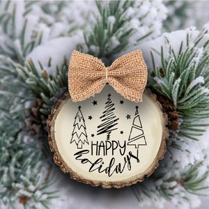 May include: A wooden Christmas bauble with a rustic brown finish. It features three stylised Christmas trees and the text "Happy Holidays". A burlap bow is tied around the top of the bauble.