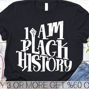 May include: Black t-shirt with white text that reads "I AM BLACK HISTORY" with a raised fist graphic. The text is stylized with a vintage font.