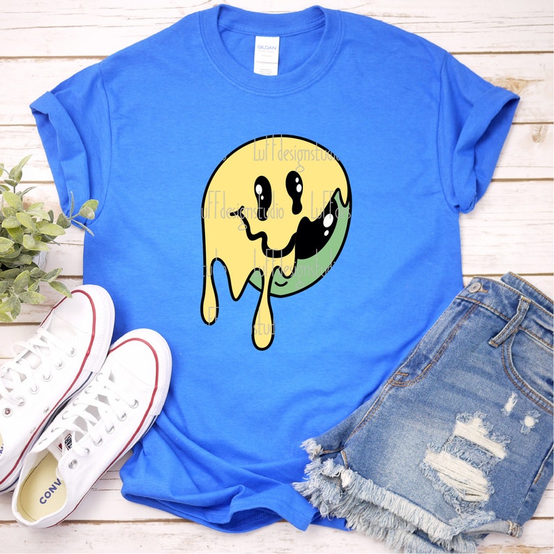 May include: A blue t-shirt featuring a yellow and green dripping smiley face graphic.