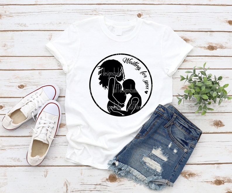 May include: White t-shirt with a black silhouette of a pregnant woman holding a child. The text "Waiting for you" is written in a circle around the silhouette.
