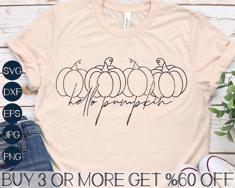 Pode incluir: Uma camiseta rosa claro com um contorno preto de quatro ab&oacute;boras e o texto "hello pumpkin" em uma fonte manuscrita.