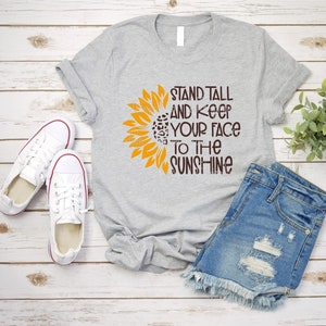 May include: Gray t-shirt with a sunflower graphic and the text "Stand Tall and Keep Your Face to the Sunshine".