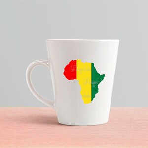 May include: White ceramic mug with a green, yellow, and red outline of the continent of Africa. The text "Luff Designs" is written on the mug.