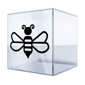 Op de afbeelding: Een zwarte en witte bij-silhouet sticker in een transparante acryl kubus.