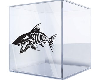 May include: A black and white silhouette of a fish skeleton with a large mouth and sharp teeth. The fish is inside a clear glass cube.