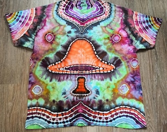 May include: A tie-dye t-shirt featuring a psychedelic mushroom design in shades of orange, green, purple, and blue. The shirt has a circular pattern with a central mushroom image.