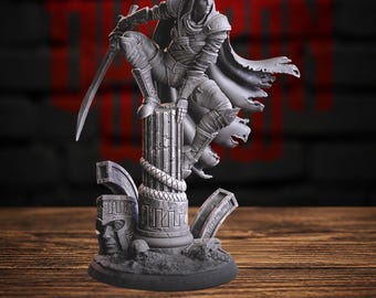May include: A grey resin miniature figurine of a hooded rogue character in a dynamic pose, perched atop a weathered stone pillar. The figure wears detailed armour, a flowing cape, and holds a sword. The base features ruins, a carved face, and a skull.