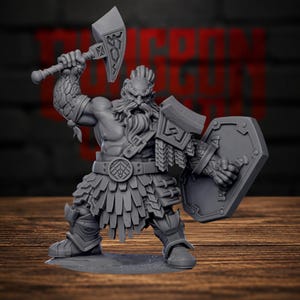 May include: A grey miniature figurine of a bearded warrior with a topknot hairstyle, holding a large axe raised in the right hand and a shield in the left. The figure wears a layered skirt, shoulder armour, and greaves, with detailed textures on the arms.