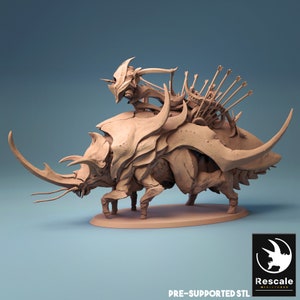 Könnte beinhalten: Ein 3D-gedrucktes Modell einer Käfer-ähnlichen Kreatur mit einem Reiter auf dem Rücken. Der Reiter hält eine Waffe und trägt einen Helm. Das Modell ist in hellbrauner Farbe gedruckt und für einen einfachen Druck vorab unterstützt.