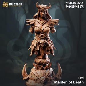 Peut inclure: Buste détaillé de Hel, la Vierge de la Mort, de la série Shadow Over Nordheim. La sculpture représente une figure féminine avec une couronne à cornes, une armure complexe et un motif de crâne. Le buste est de couleur marron clair et se détache sur un fond sombre.