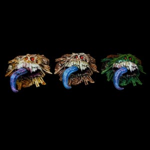 Peut inclure: Trois sculptures monstrueuses avec des bouches ouvertes et de longues langues bleues. Chacune a une palette de couleurs différente : marron, marron-vert et vert. Les sculptures ont des yeux rouges et des dents pointues, avec un aspect texturé et épineux. Le fond est noir.