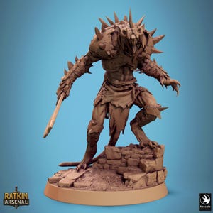 Puede incluir: Figura marrón detallada de una criatura monstruosa con púas afiladas, armadura y una espada. La figura se alza sobre una base de piedra sobre un fondo azul. El texto "RATKIN ARSENAL" es visible.