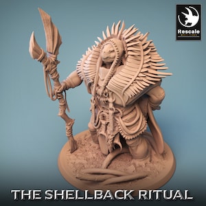 May include: A detailed miniature figurine of a turtle-like creature wearing a feathered headdress and holding a staff. The figurine is painted in a light brown color and is standing on a base with a textured surface. The text "THE SHELLBACK RITUAL" is printed below the base.