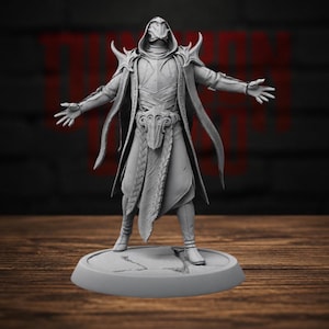May include: A gray resin miniature figure of a hooded character in an expansive pose, wearing layered robes, ornate shoulder pauldrons, and a detailed belt buckle, standing on a circular base with a cracked stone texture design.