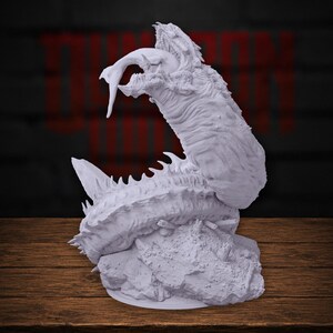 May include: A light gray, unpainted resin miniature of a monstrous, worm-like creature with a segmented, spiky body and a wide, gaping maw. The creature is coiled upon a rocky, textured base, with its head arched upward and a long tongue extended.