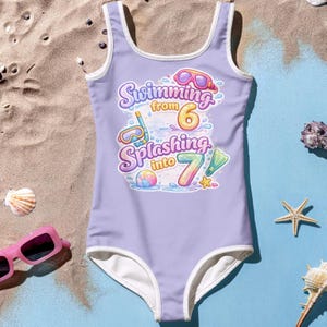 May include: A lavender one-piece swimsuit with white trim. The swimsuit features the text "Swimming from 6 Splashing into 7" in a colorful, playful font, along with illustrations of goggles, flippers, and a beach ball.