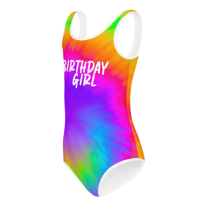 Puede incluir: Un traje de ba&ntilde;o tie-dye colorido con tirantes blancos y el texto "Birthday Girl" en blanco.