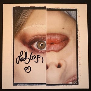 May include: A split image featuring a close-up of a person's face. One side shows an eye with brown eyeshadow, the other side shows a closed lip. The text "ladybags" is written in black ink with a heart symbol.