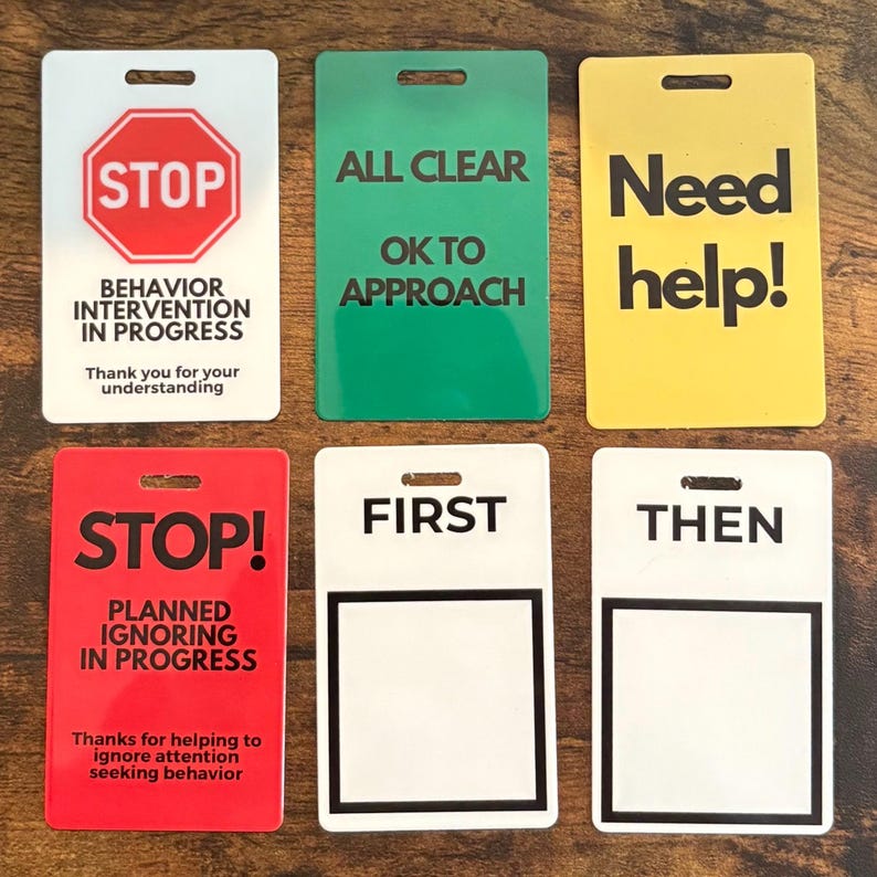 Puede incluir: Seis letreros rectangulares de colores, incluyendo rojo, verde y amarillo. Cada letrero tiene texto como "STOP", "ALL CLEAR" y "Need help!". Los letreros est&aacute;n dise&ntilde;ados con un agujero en la parte superior para colgar.