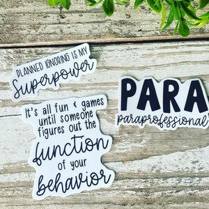 K&ouml;nnte beinhalten: Drei wei&szlig;e Aufkleber mit schwarzem Text. Der erste Aufkleber sagt "Geplantes Ignorieren ist meine Superkraft". Der zweite Aufkleber sagt "Es macht alles Spa&szlig; und ist ein Spiel, bis jemand die Funktion deines Verhaltens herausfindet". Der dritte Aufkleber sagt "PARA paraprofessionell".