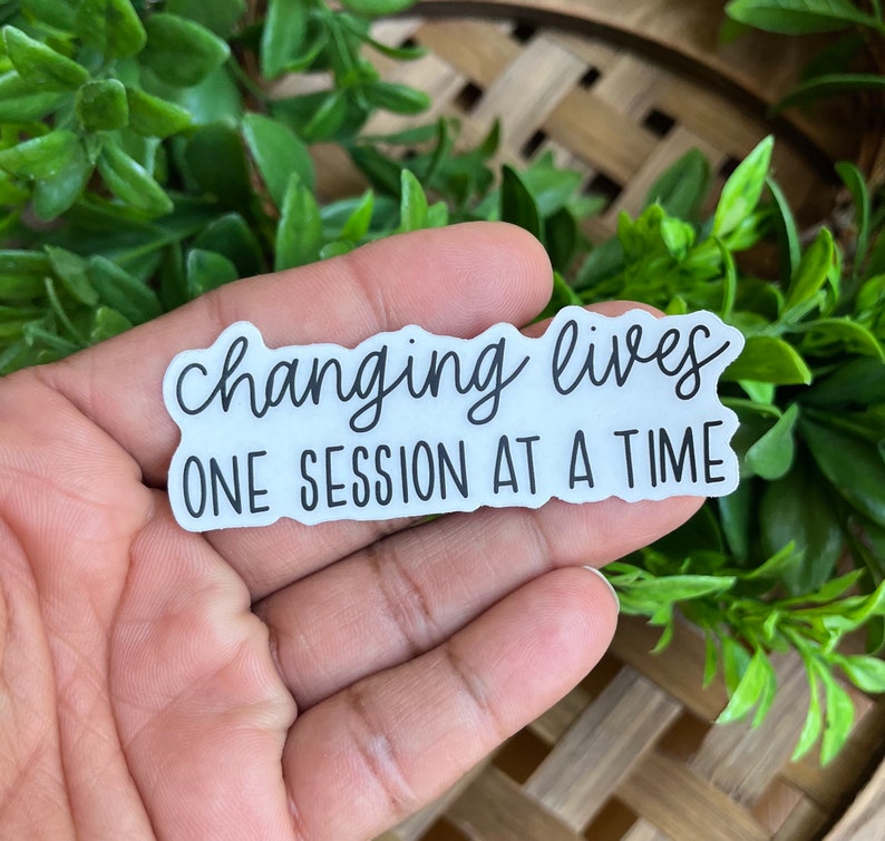 May include: White sticker with black text that reads "Changing lives one session at a time".