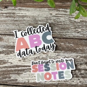May include: Two stickers with colorful letters and text. The first sticker says "I collected ABC data today". The second sticker says "Don't forget to write your SESSION NOTES".