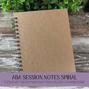 May include: A brown spiral notebook with the text "ABA SESSION NOTES SPIRAL 7.25x9.25" HEAVYWEIGHT RECYCLED CHIPBOARD" printed on the front.