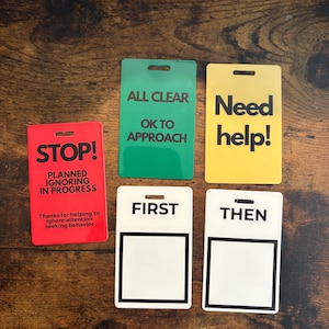 Puede incluir: Un conjunto de tarjetas de comunicaci&oacute;n rectangulares y coloridas. Las tarjetas son rojas, verdes, amarillas y blancas, con texto negro. La tarjeta roja dice "&iexcl;ALTO!" y "IGNORANDO PLANIFICADO EN CURSO". Otras tarjetas dicen "TODO CLARO", "&iexcl;Necesito ayuda!", "PRIMERO" y "LUEGO".