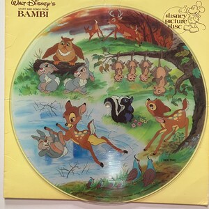May include: A vintage Disney picture disc featuring characters from the animated film "Bambi." The disc showcases colorful illustrations of Bambi, Thumper, Flower, and other forest animals in a woodland scene. The disc is labeled "Side Two."