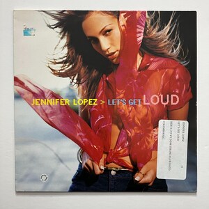 May include: A red and pink fabric draped over a woman's shoulders. The woman is wearing a blue denim shirt and jeans. The text "Jennifer Lopez > Let's Get Loud" is printed on the image.