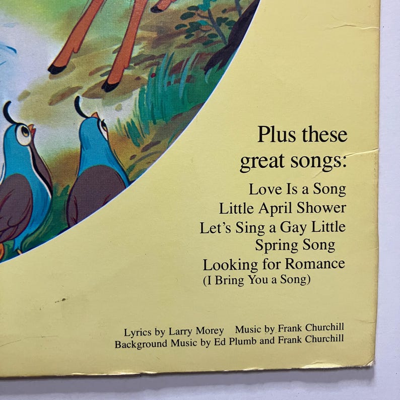 May include: A vintage book page with illustrations of blue birds and a deer. Text on the page reads "Plus these great songs: Love Is a Song, Little April Shower, Let's Sing a Gay Little Spring Song, Looking for Romance". Lyrics by Larry Morey.