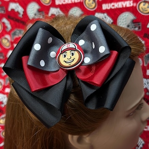 May include: A black, red, and gray bow with white polka dots and a red, white, and brown Ohio State Buckeyes logo button in the center.