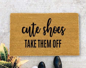 May include: A brown doormat with the text "cute shoes take them off" in black lettering.