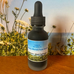 May include: A dark glass bottle with a black dropper top and a white label that reads "NANA'S NATURAL'S Beauty Blend Face Serum". The label also lists the ingredients: "Maple Leaf Extract, Astaxanthin, Camellia Oil, Essential Oils".