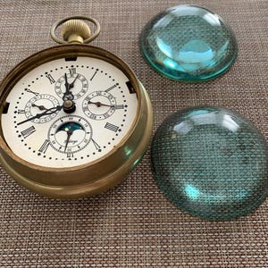 May include: A white ceramic mug with a black handle and the text "But First, Coffee" in a black, bold font. The mug is on a white surface.